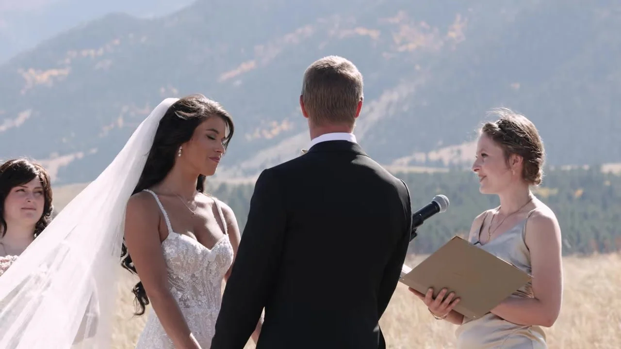 Close vows with Sierra in spaghetti strap lace and the officiant smiling at 3 Peaks Ranch