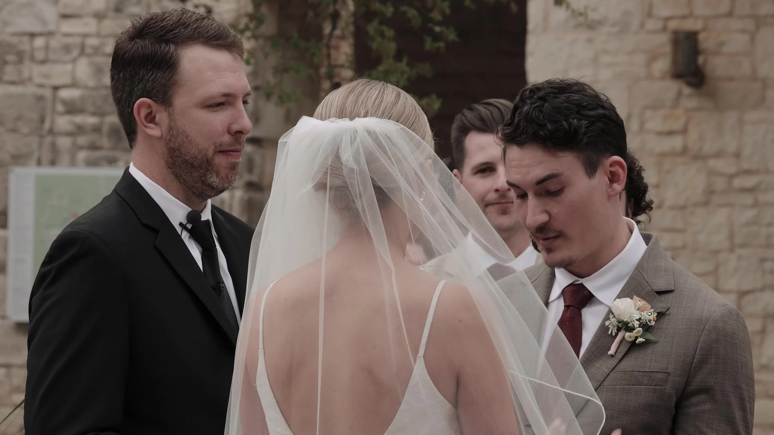 Chris looking at Heather during vows with her veil in the foreground at Lady Bird Johnson Wildflower Center in Austin, Texas