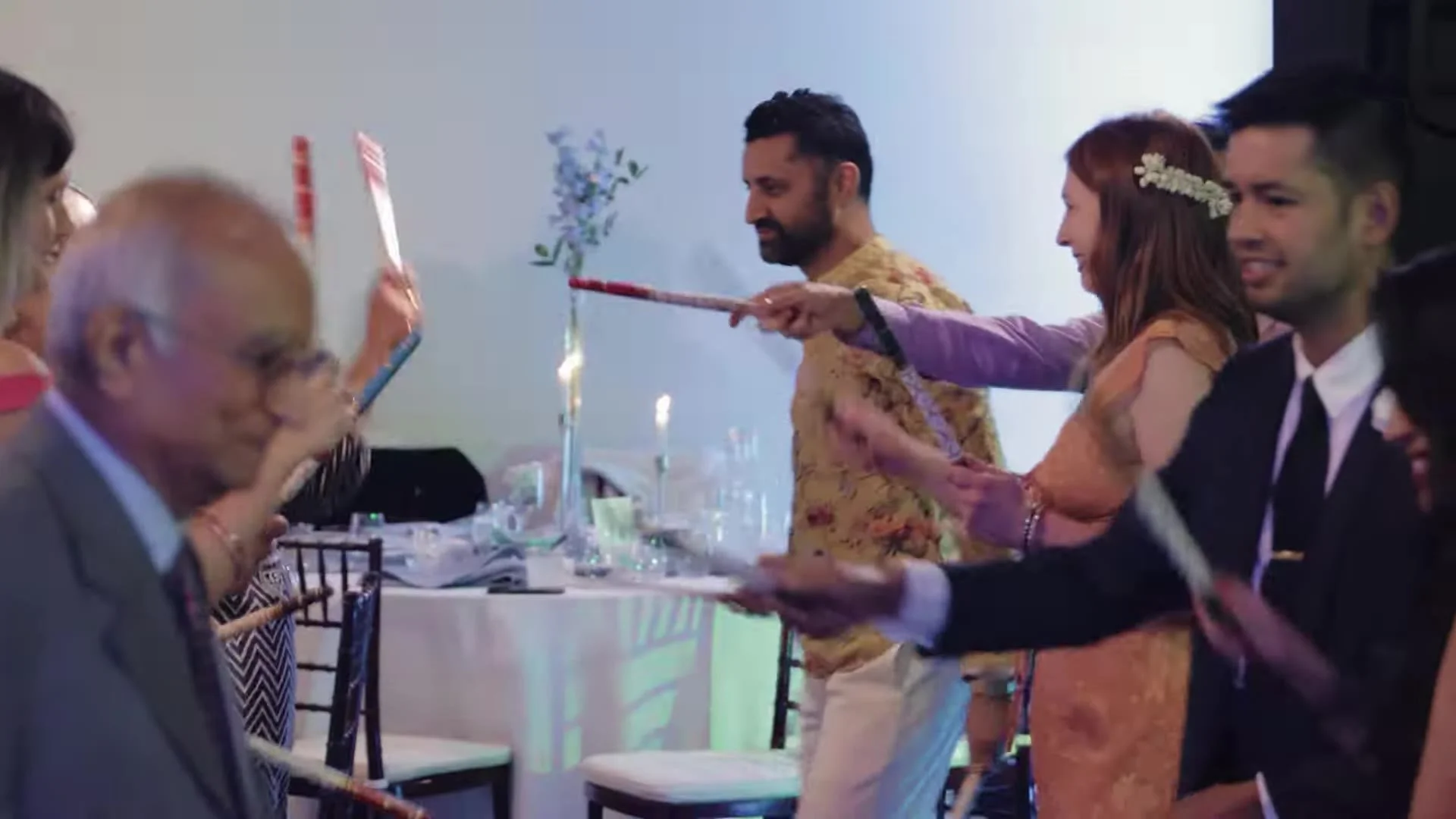 Guests playing dandiya with decorated sticks on the reception dance floor at The Terrace Club Indian wedding in Austin, Texas