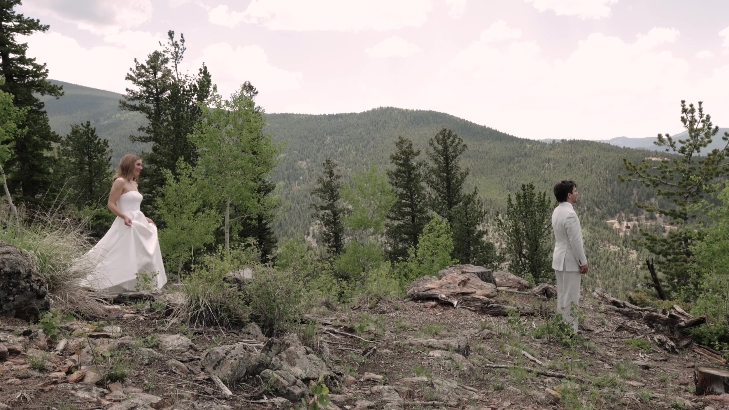 Bride and groom standing apart on a rocky pine hillside at Northstar Gatherings in Idaho Springs, Colorado