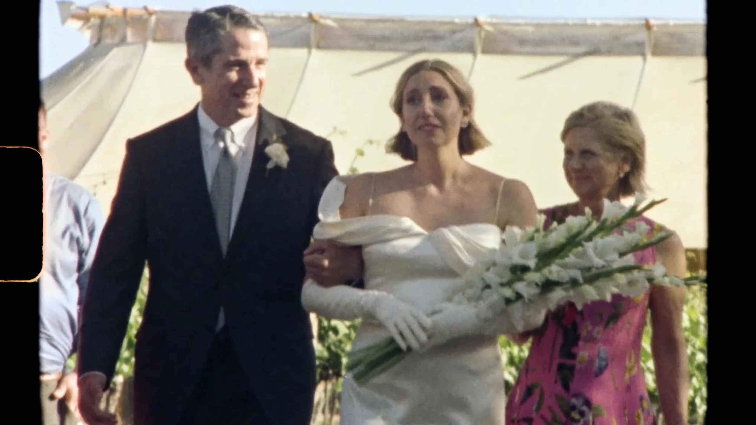 Sarah walking the white aisle through vineyard ceremony seating at Camp Lucy Vineyards in Austin, Texas