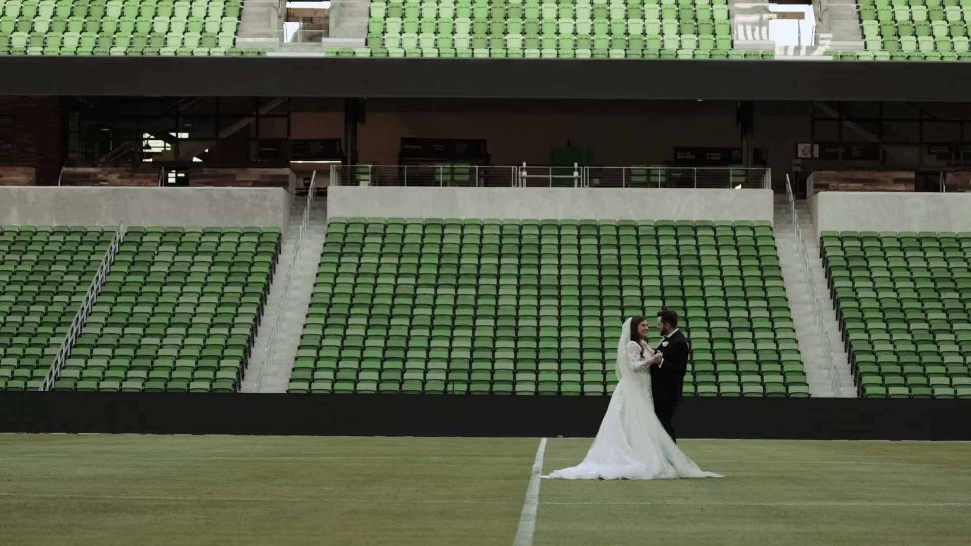 Gabby and Nic standing close together on the soccer field at Q2 Stadium in Austin, Texas
