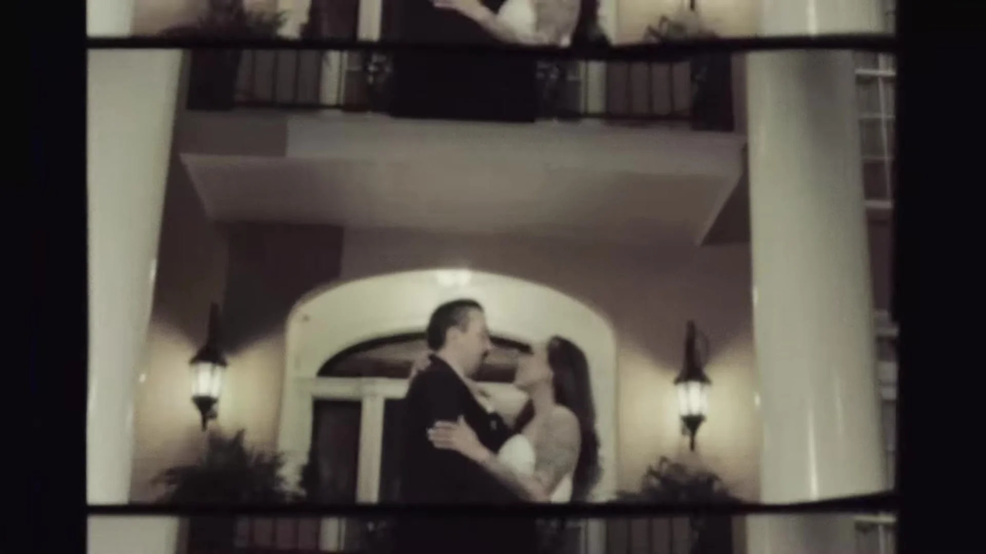 Blair and Gustavo embracing between white columns at Southern Oaks Plantation in New Orleans, vintage film frame
