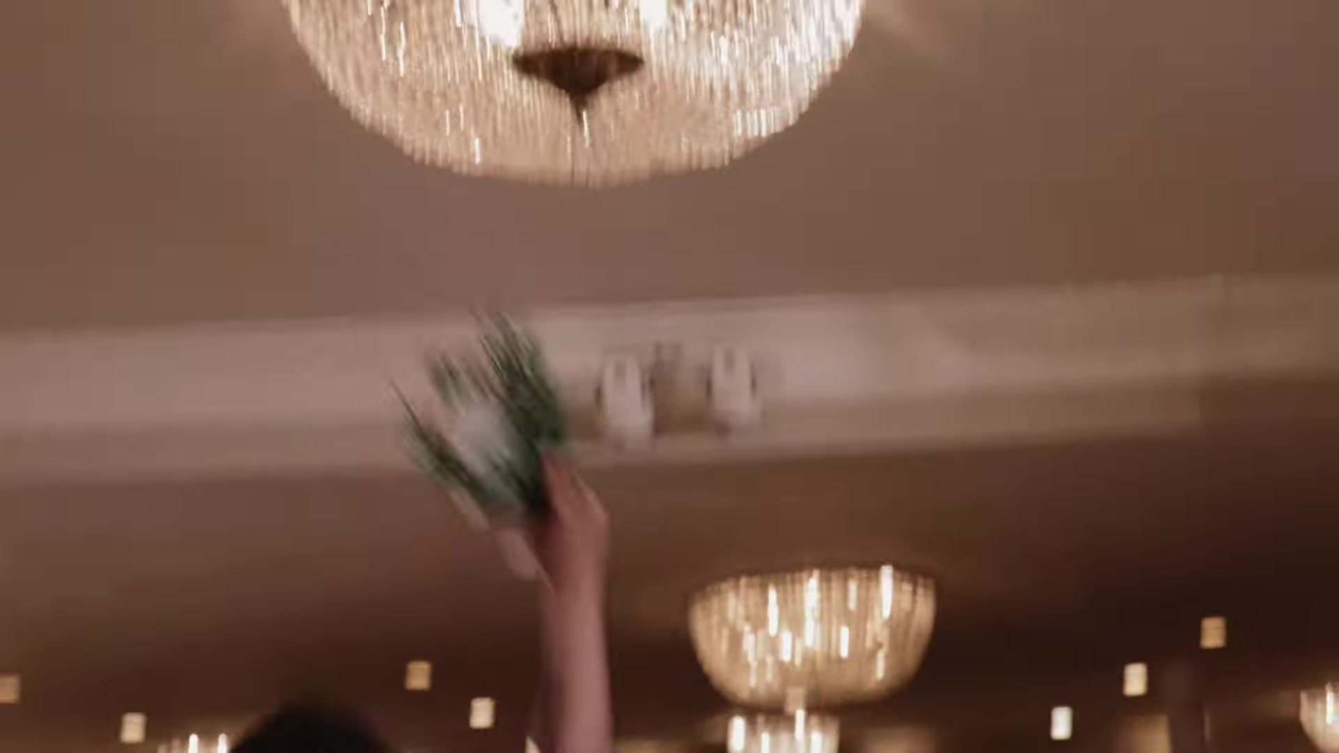Crystal chandeliers and a raised bouquet in motion at the Southern Oaks Plantation reception in New Orleans