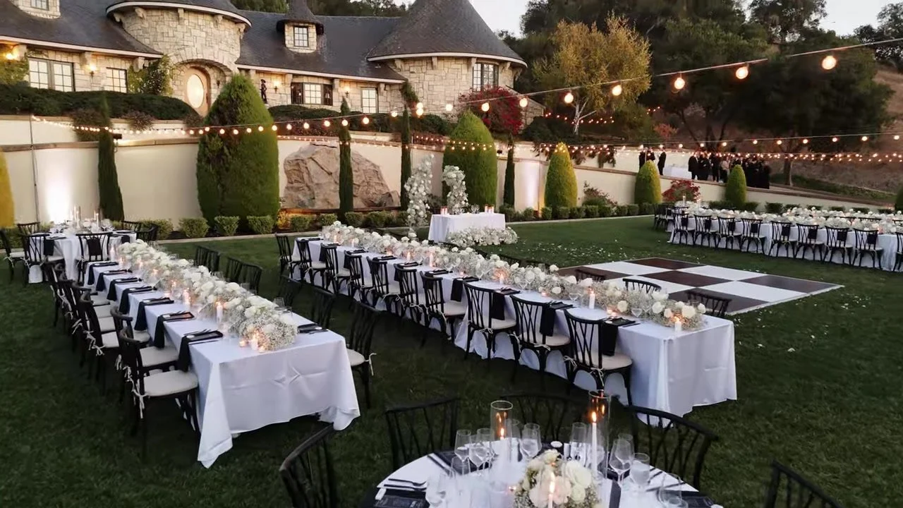 Twilight reception: banquet tables, checkered dance floor, bistro lights
