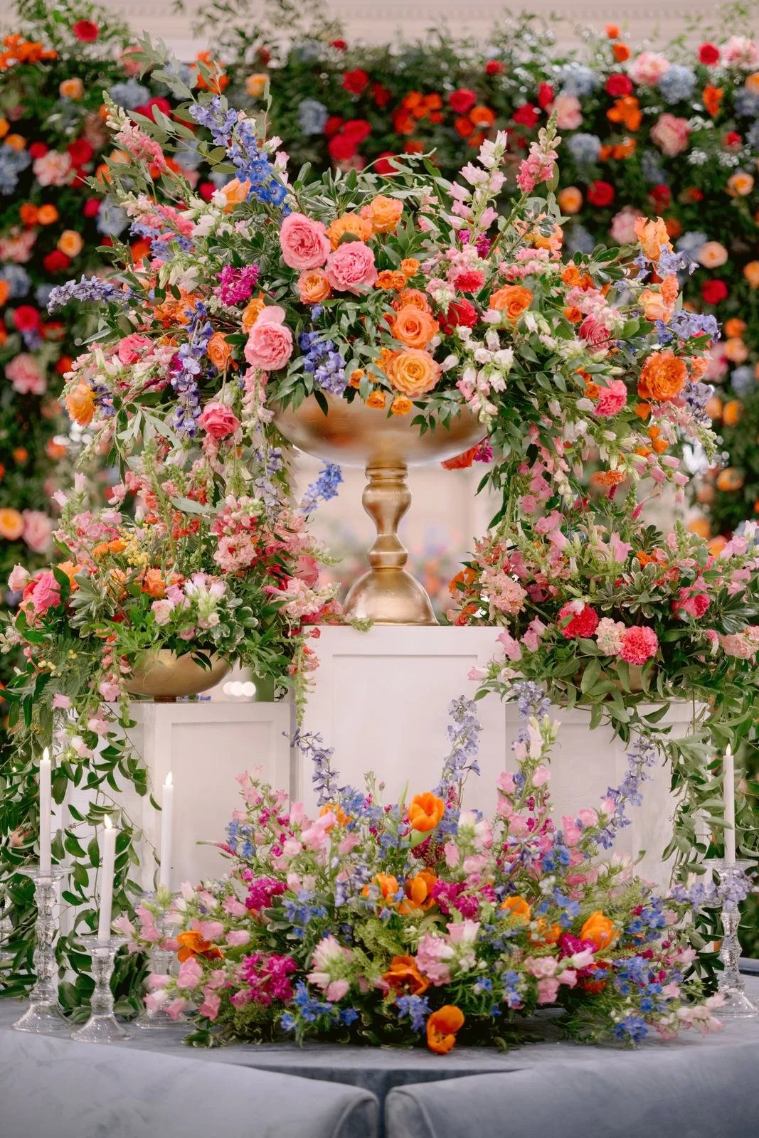 Large colorful floral arrangement on a gold pedestal