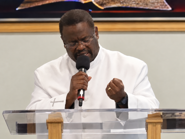 Joseph C. Black Jr. preaching in a white suit. Restored image from a Facebook message.