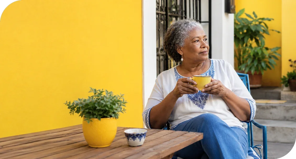 A woman relaxing outdoors with a mug in her hands.