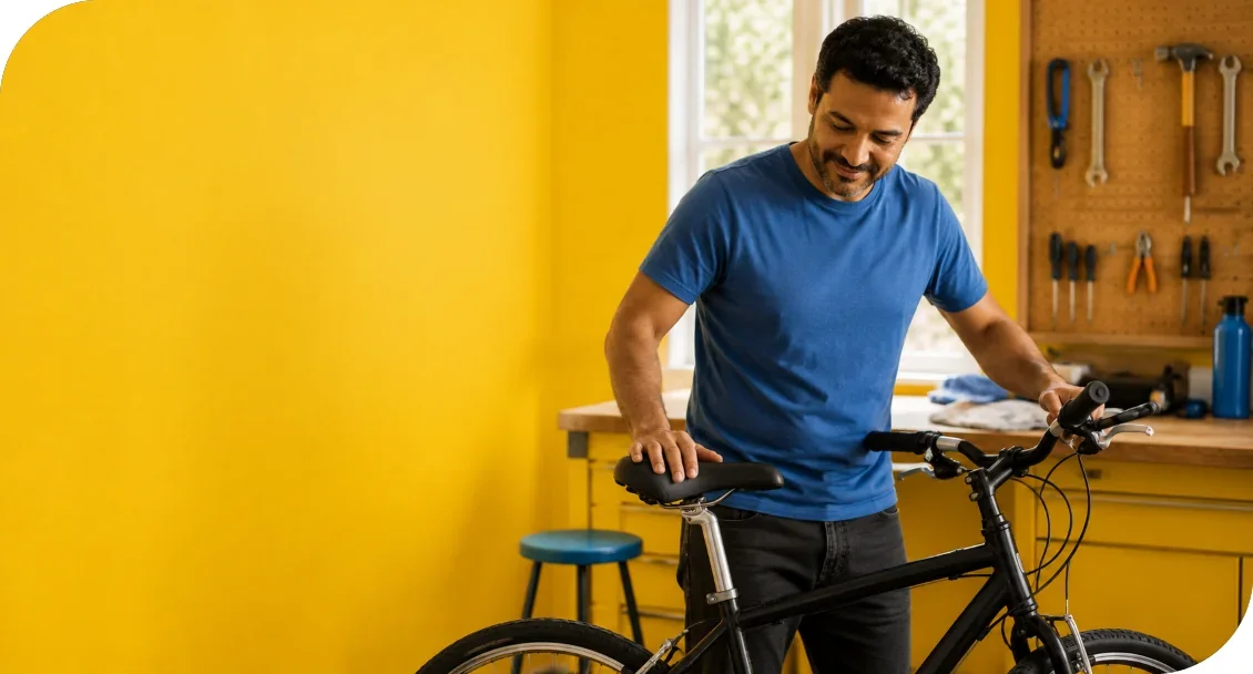 A man standing beside a bicycle in a workshop.