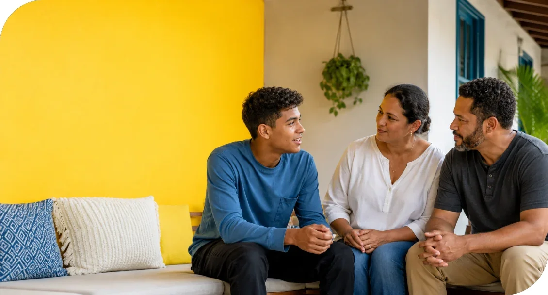 Three people sitting together and talking on a couch.