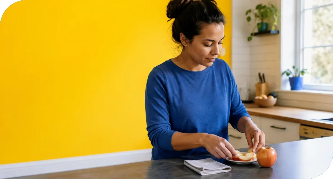 A woman preparing food at a kitchen counter.