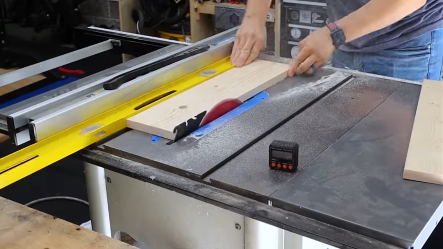 A 4-ft level used as a straight edge reference alongside a board on the table saw to joint an edge without a jointer