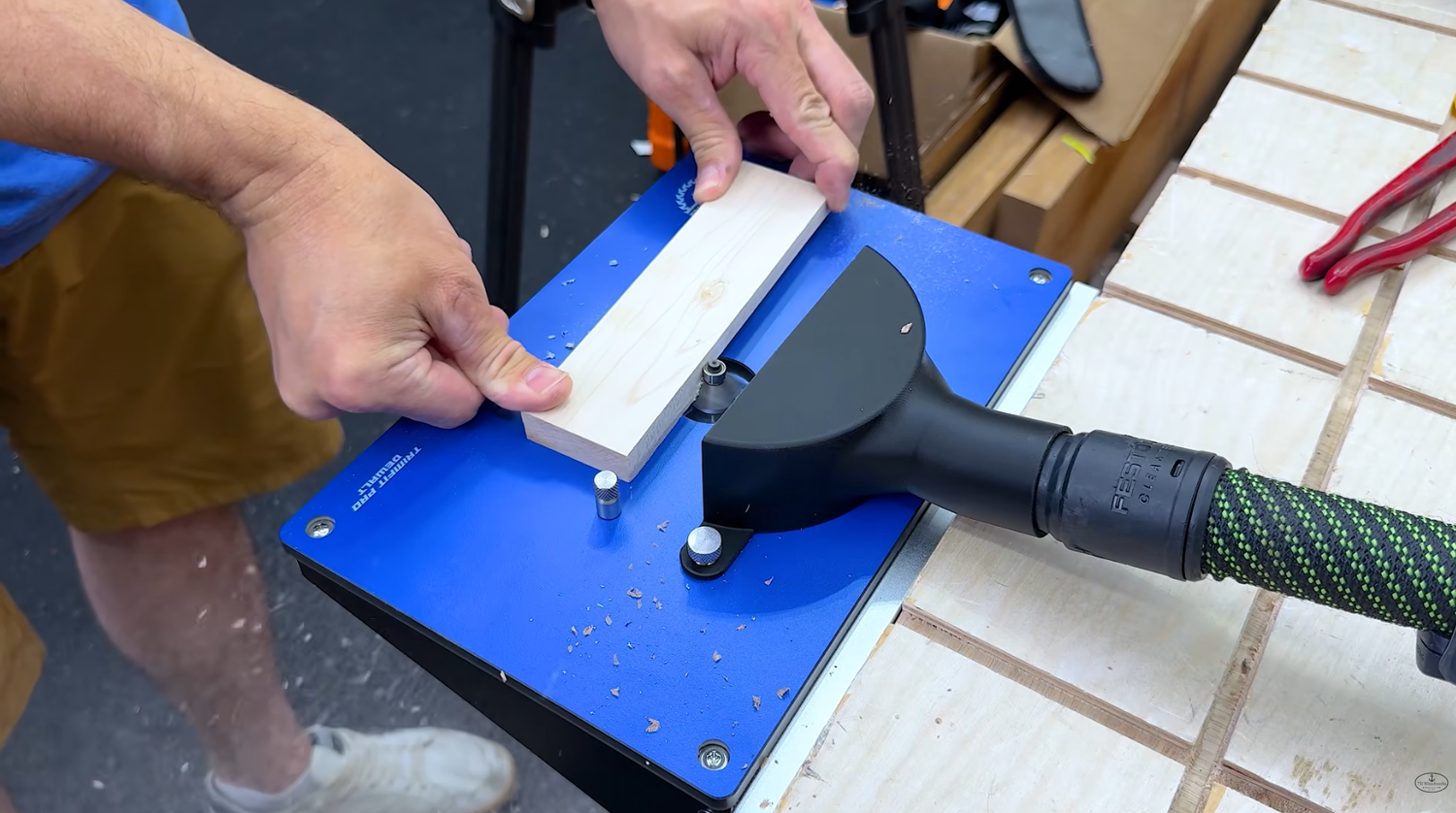 Running a chamfer pass on a small wood workpiece across the phenolic top of the Wood Grain Junkie BenchMount router table