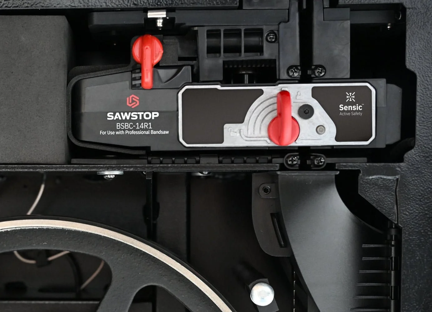 SawStop Sensic brake cartridge mounted below the table of the Professional Bandsaw with the blade running through it