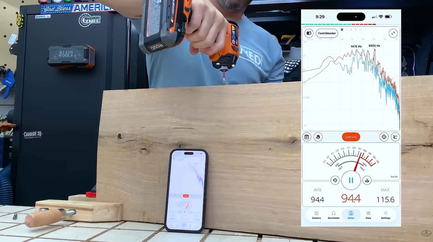 Decibel meter reading on a phone while the RIDGID NUKE Stealth Force oil pulse impact driver drives a 4 inch screw into white oak