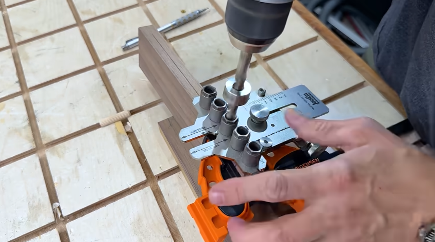 JessEm stainless steel dowel jig on a board with dowel holes drilled