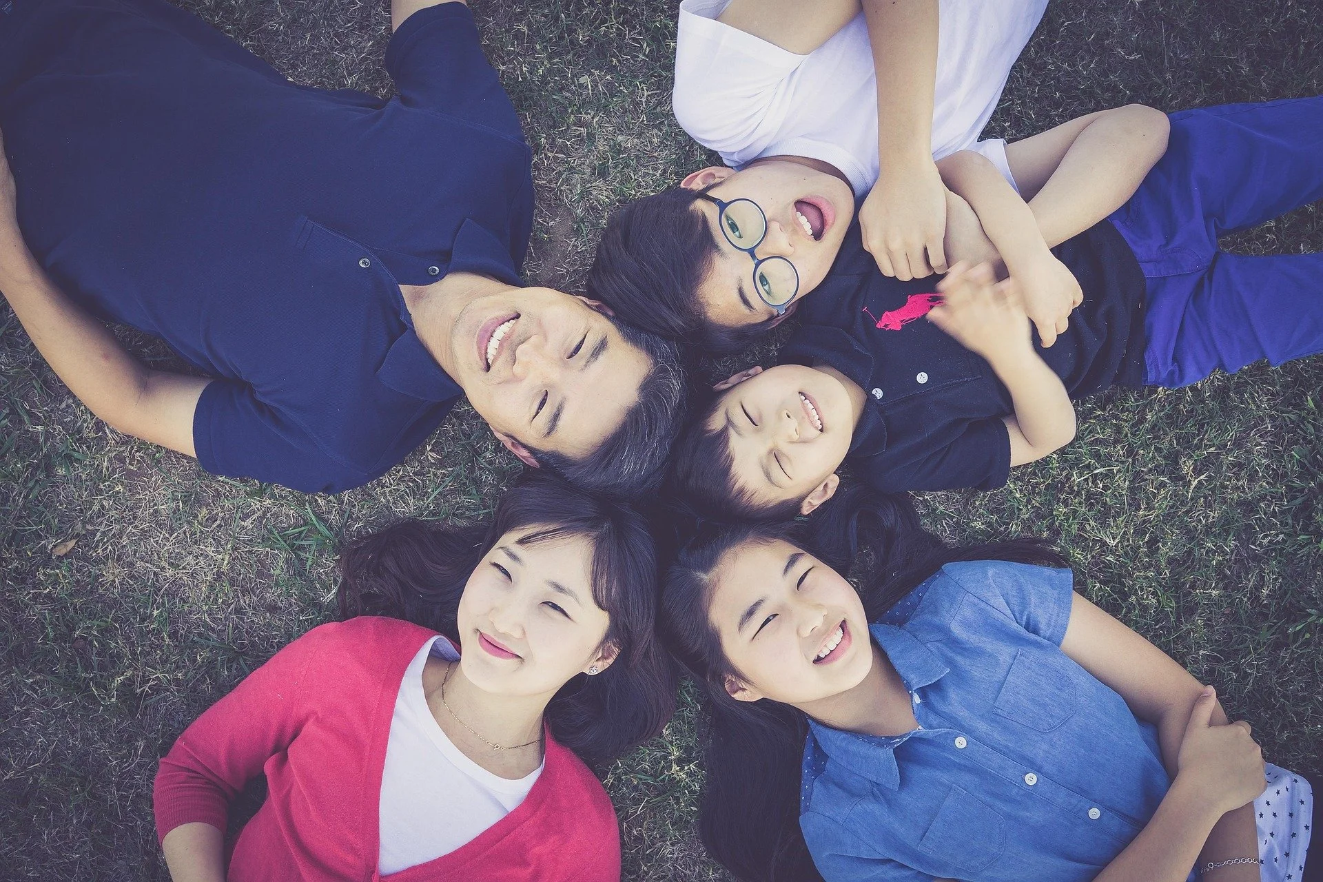 Family lying together on grass laughing
