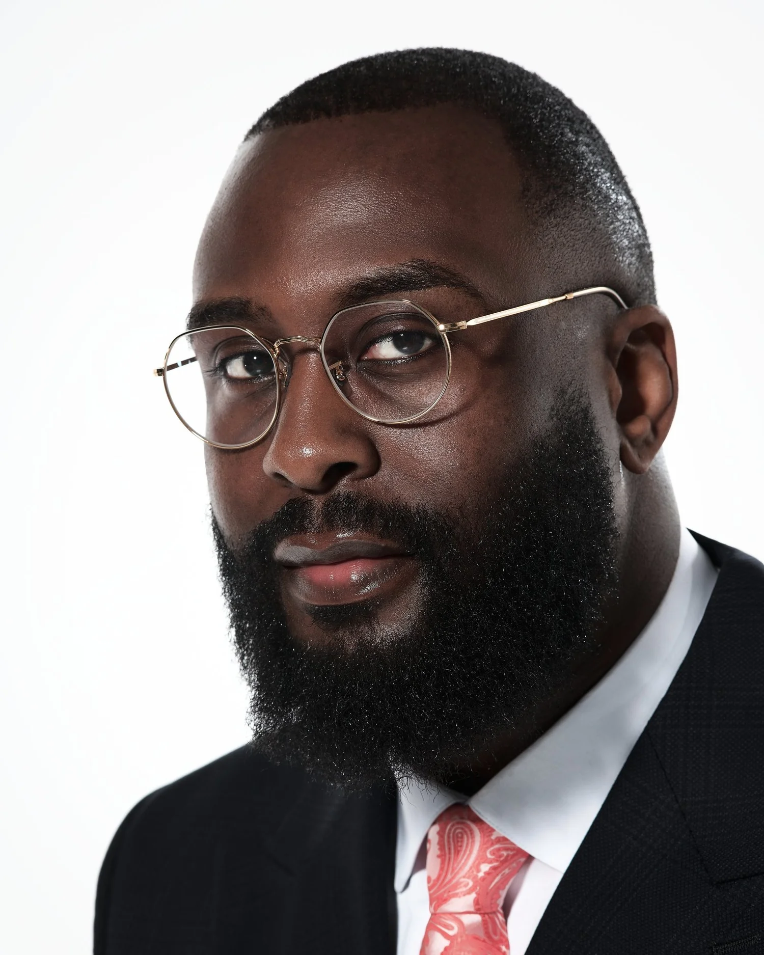 Corporate headshot of a man in a suit and glasses