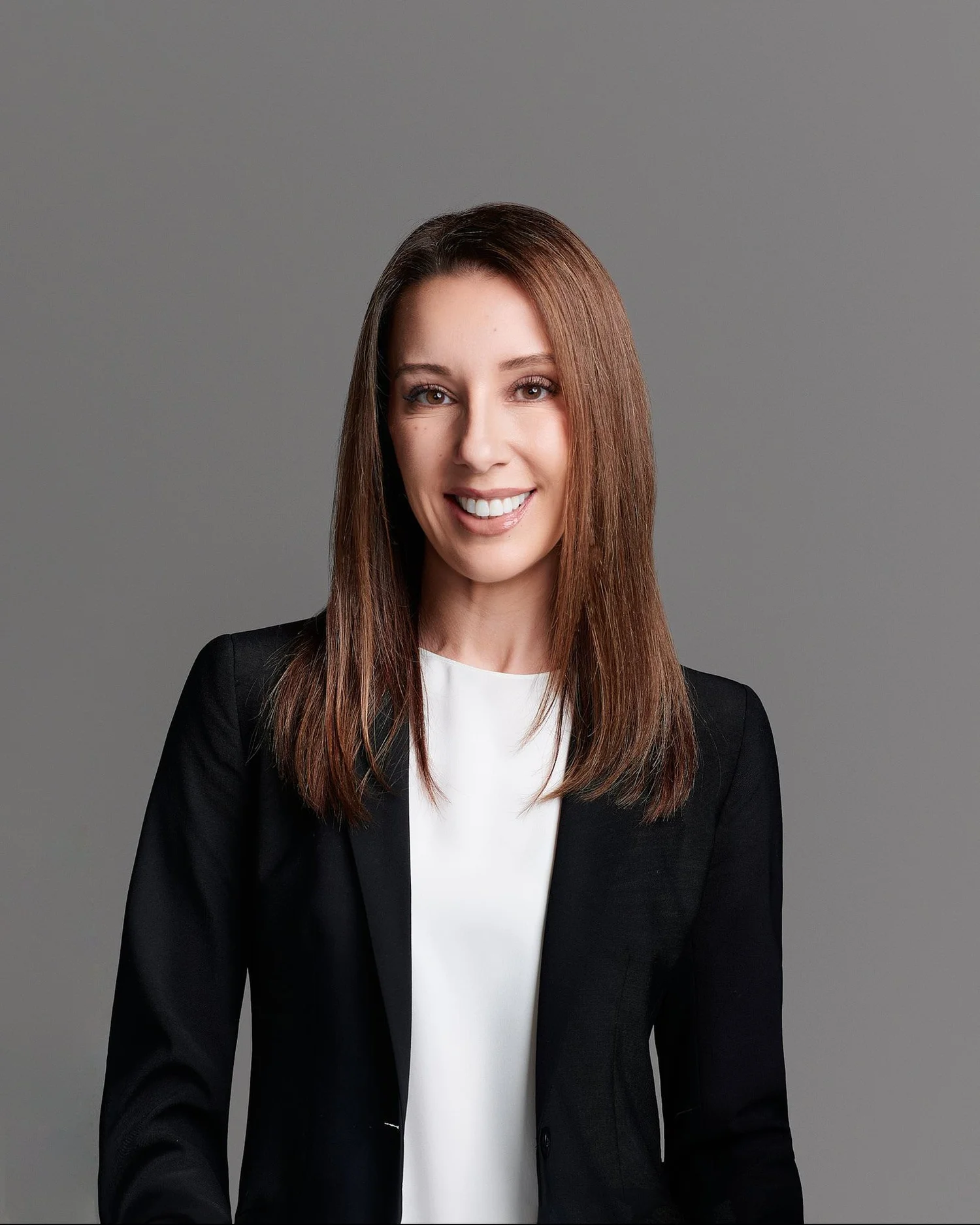 Corporate headshot of a woman in a black blazer