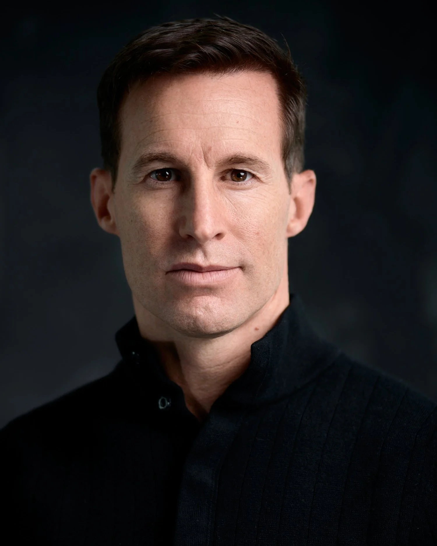 Professional headshot on a dark background