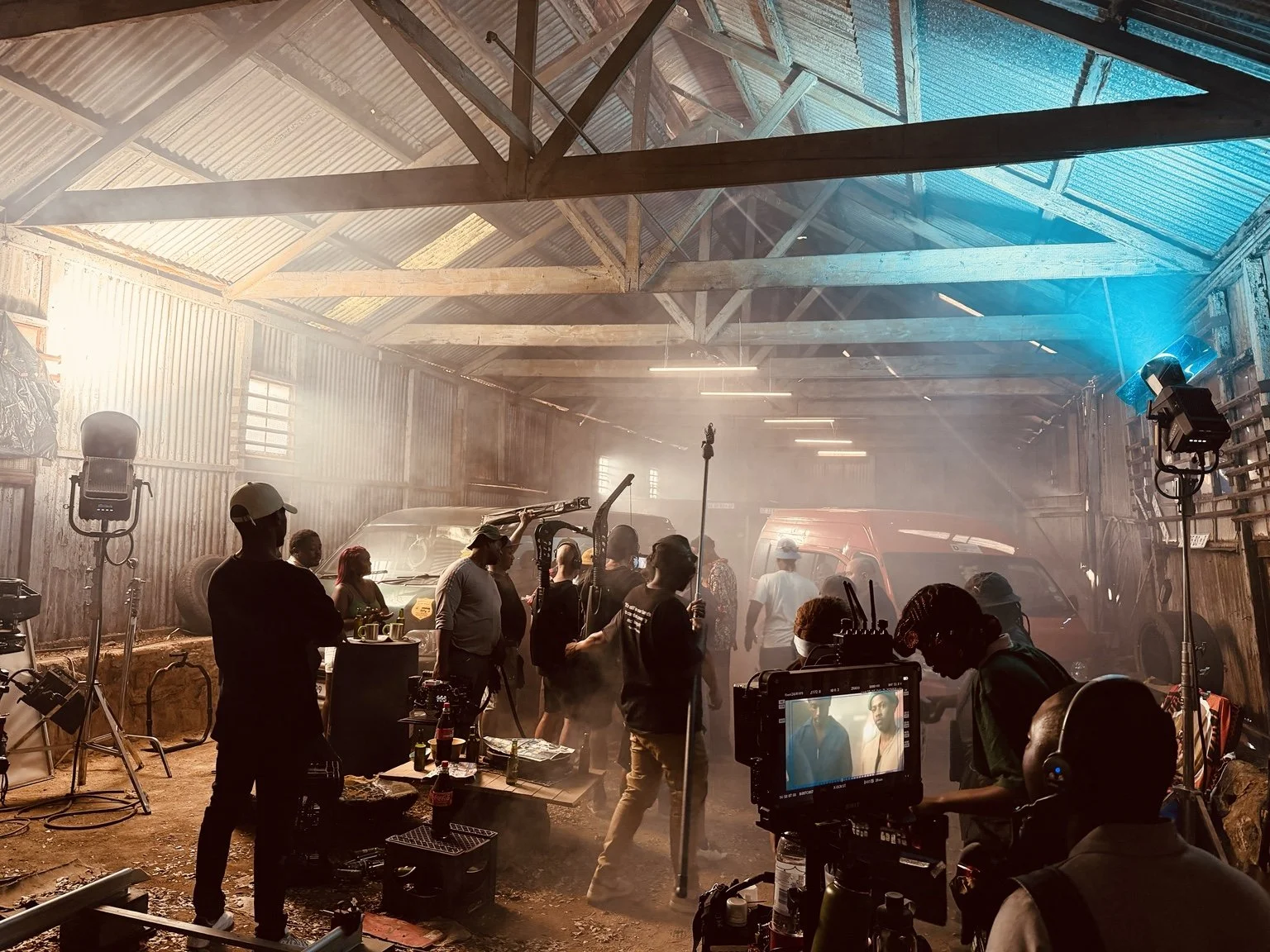 Film crew, camera and monitor on a warmly lit commercial set