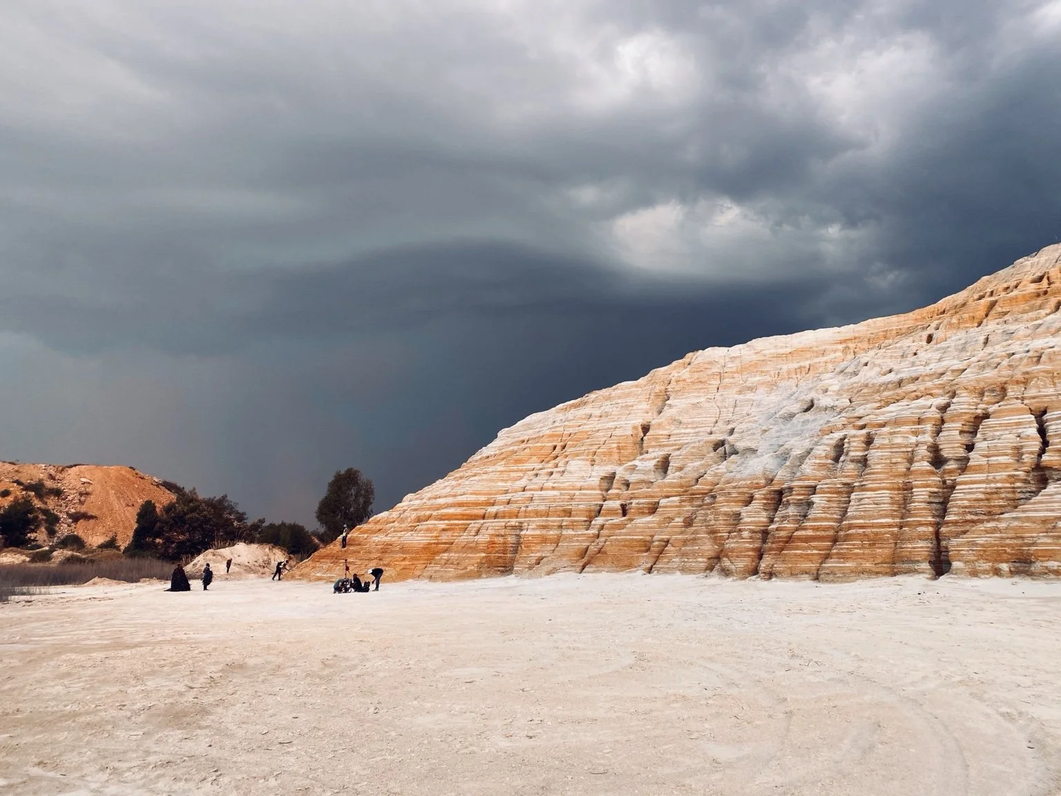 Storm clouds above a sunlit quarry