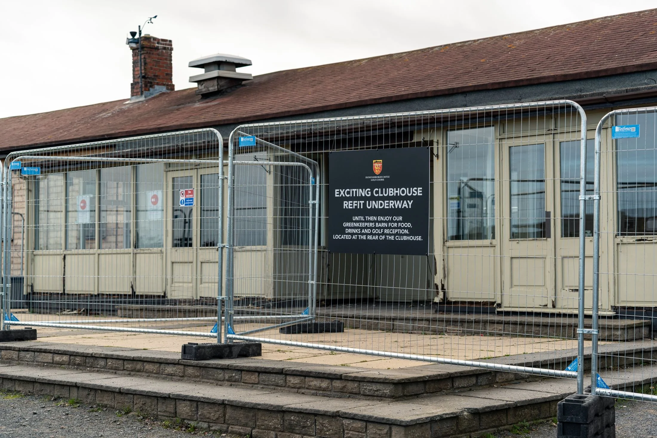 The fenced-off clubhouse at Dunstanburgh Castle Golf Course with the Exciting Clubhouse Refit Underway sign