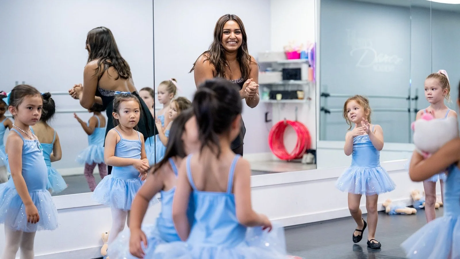 Dance studio owner working with students in a structured class environment