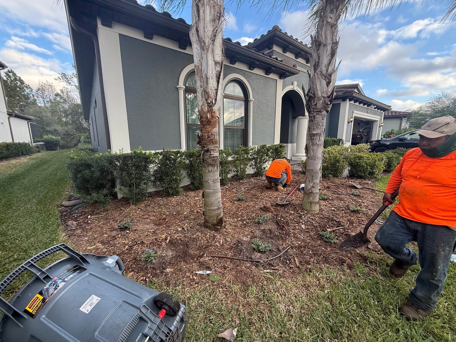 RLC Lawn & Landscape crew in orange shirts planting a new foundation bed at a Florida home