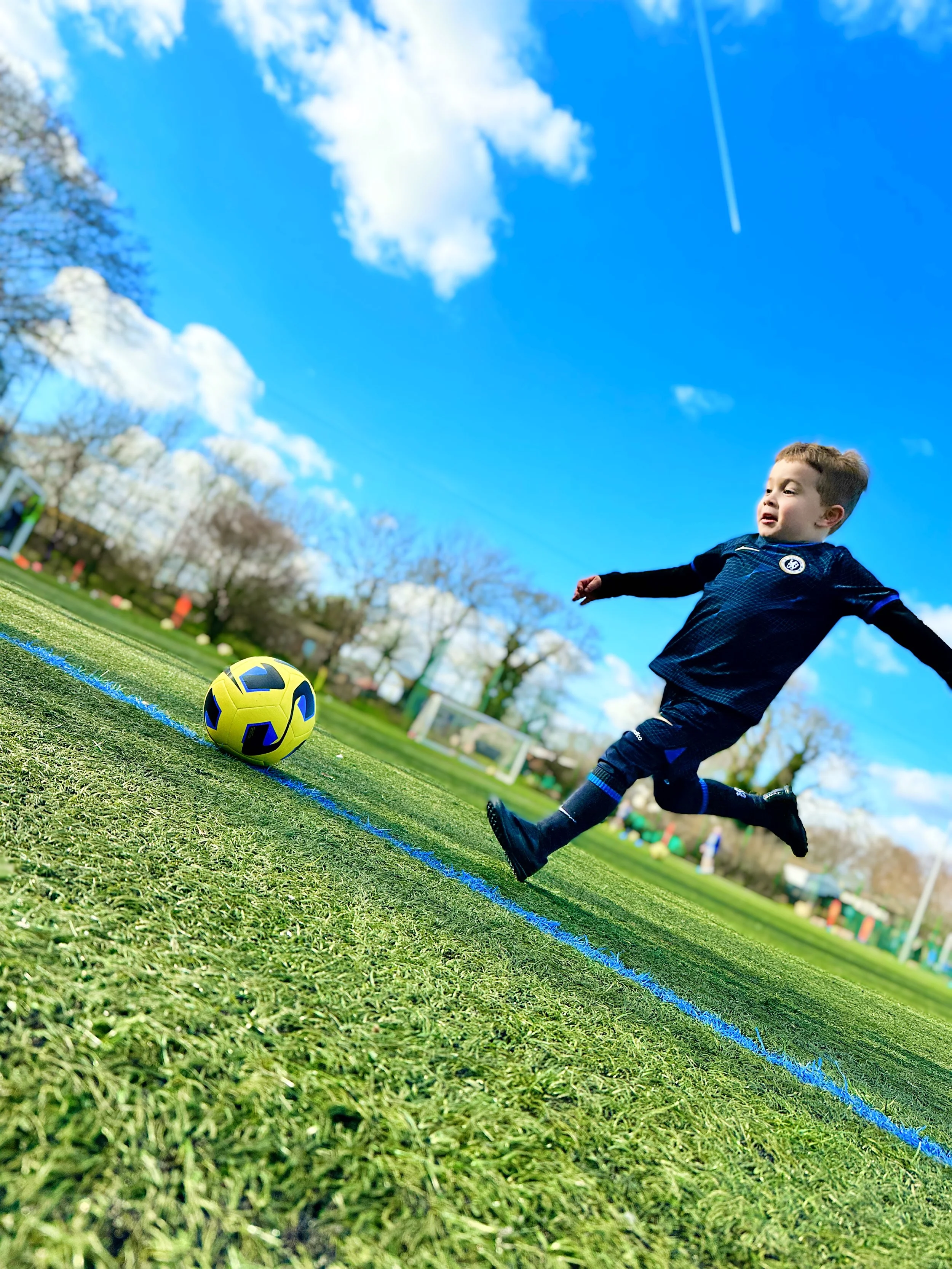 Young footballer shooting at coaching