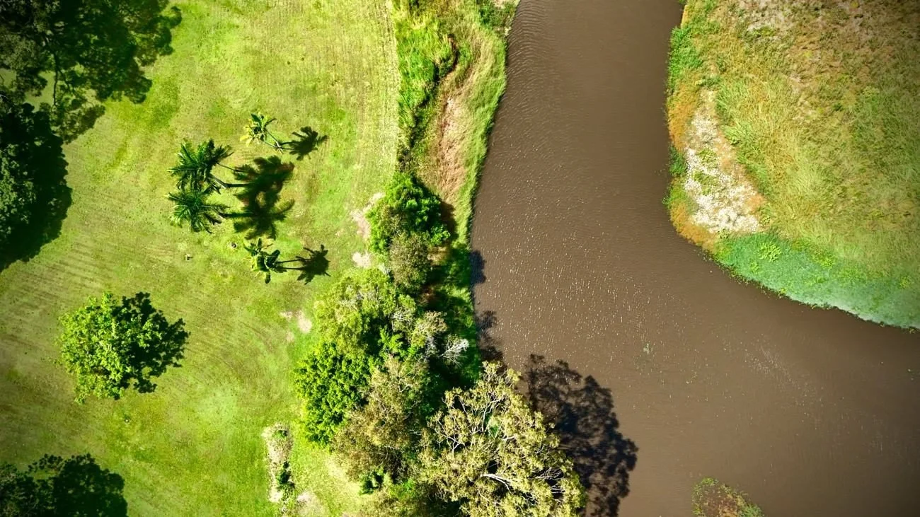 Aerial drone photo of a river bend and green parkland