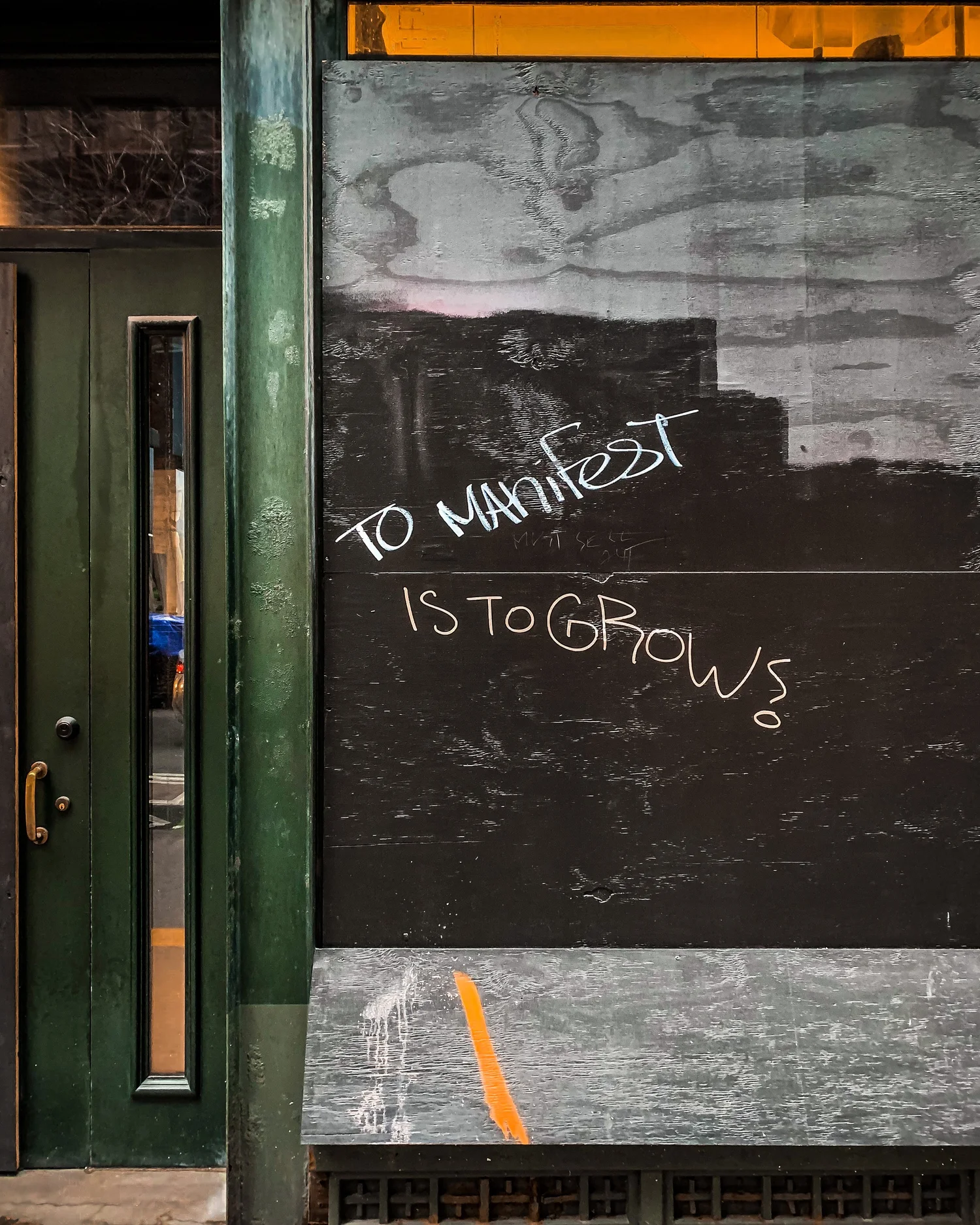 Graffiti reading 'to manifest is to grow'