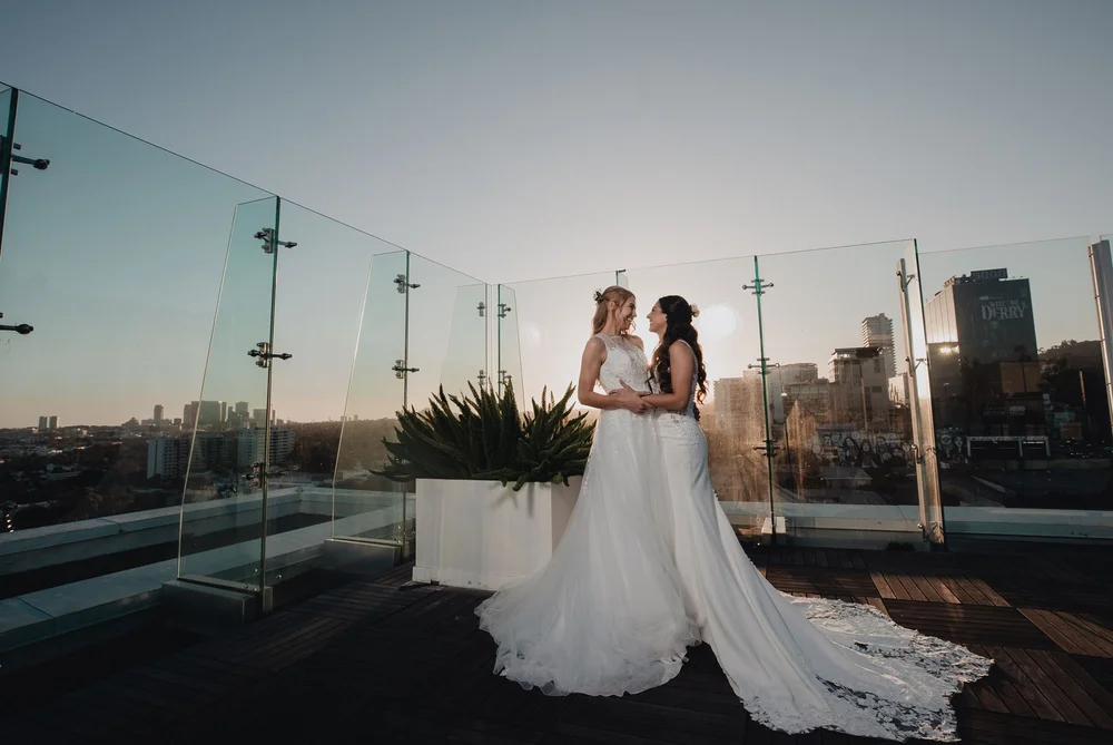 Two brides on the rooftop terrace of The London West Hollywood at sunset