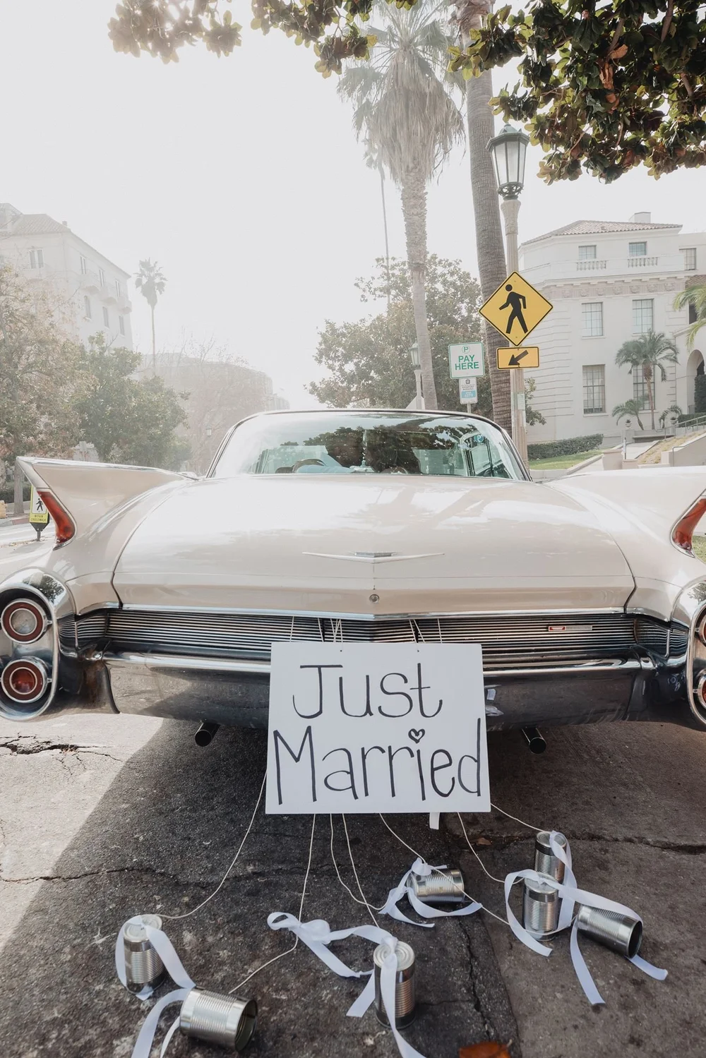 Just Married sign hanging from the back of a vintage car after an elopement