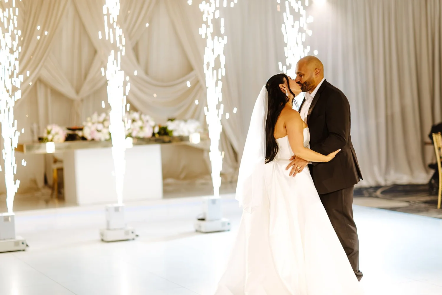 First dance between cold-spark fountains in the ivory-draped ballroom at Glenoaks Ballroom