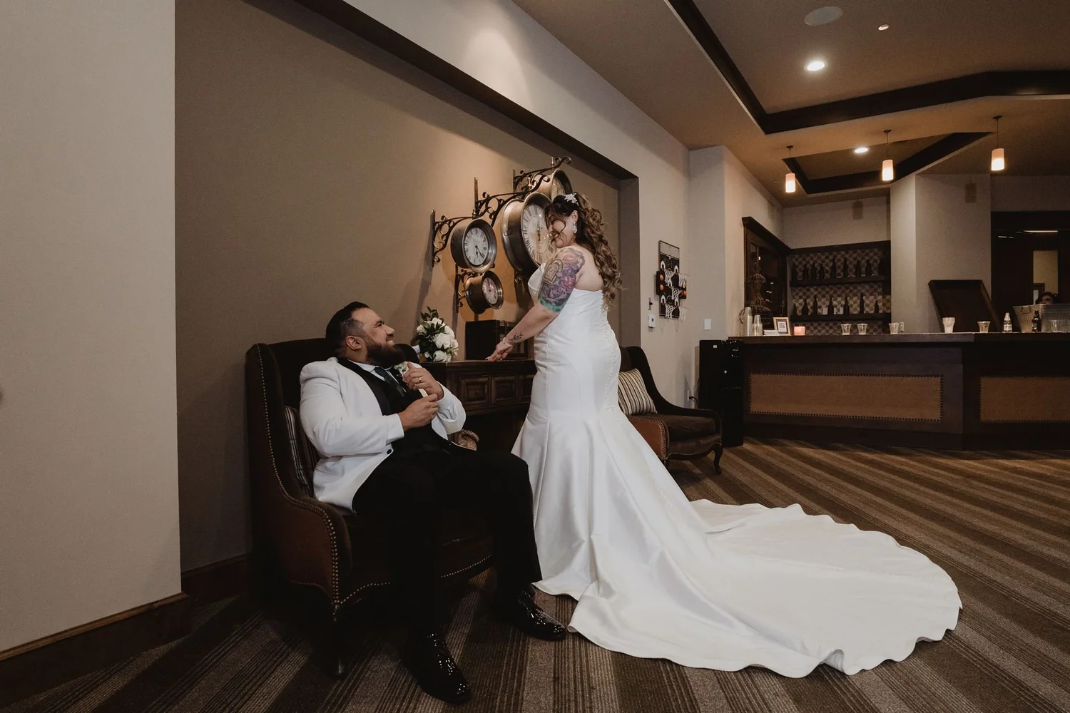 Couple in a leather armchair in the wood-paneled lounge at Vellano Estate