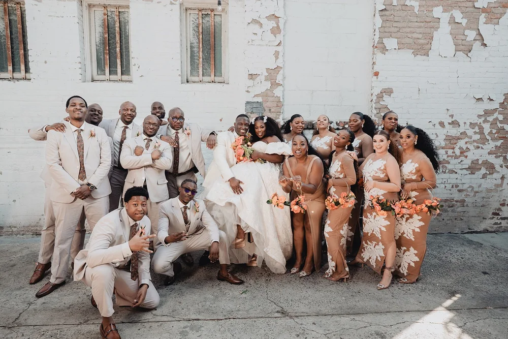 Wedding party in cream and copper against the weathered painted brick of the alley wall outside Valentine DTLA