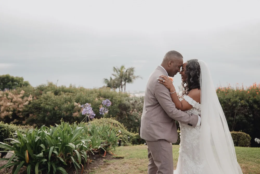 Couple forehead to forehead in the gardens at La Venta Inn