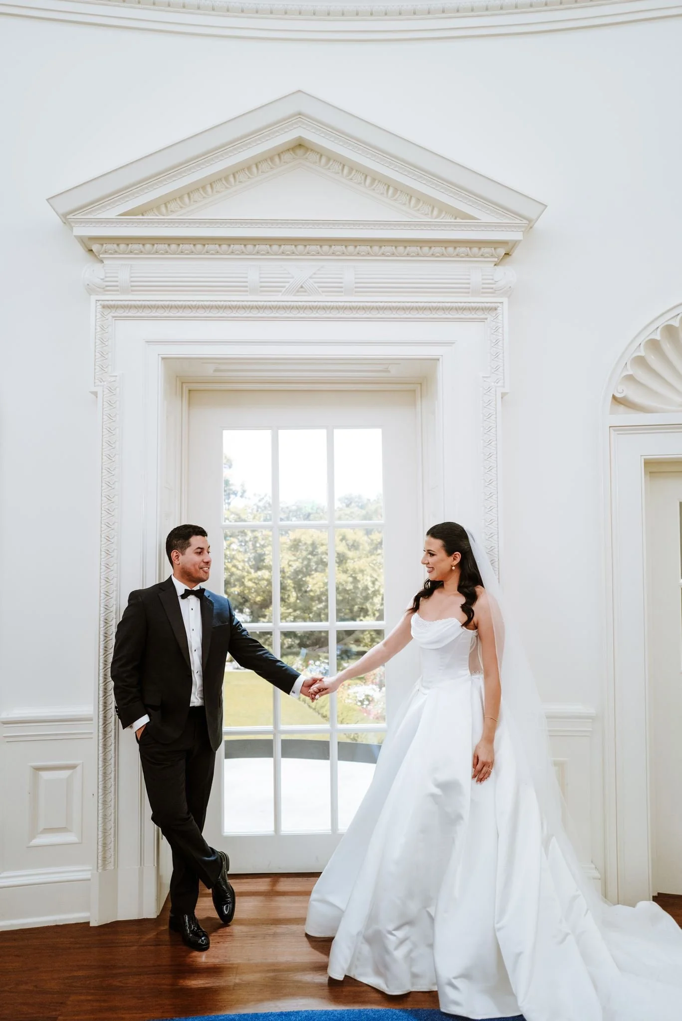 Couple by a white French door with classical molding at the Nixon Library