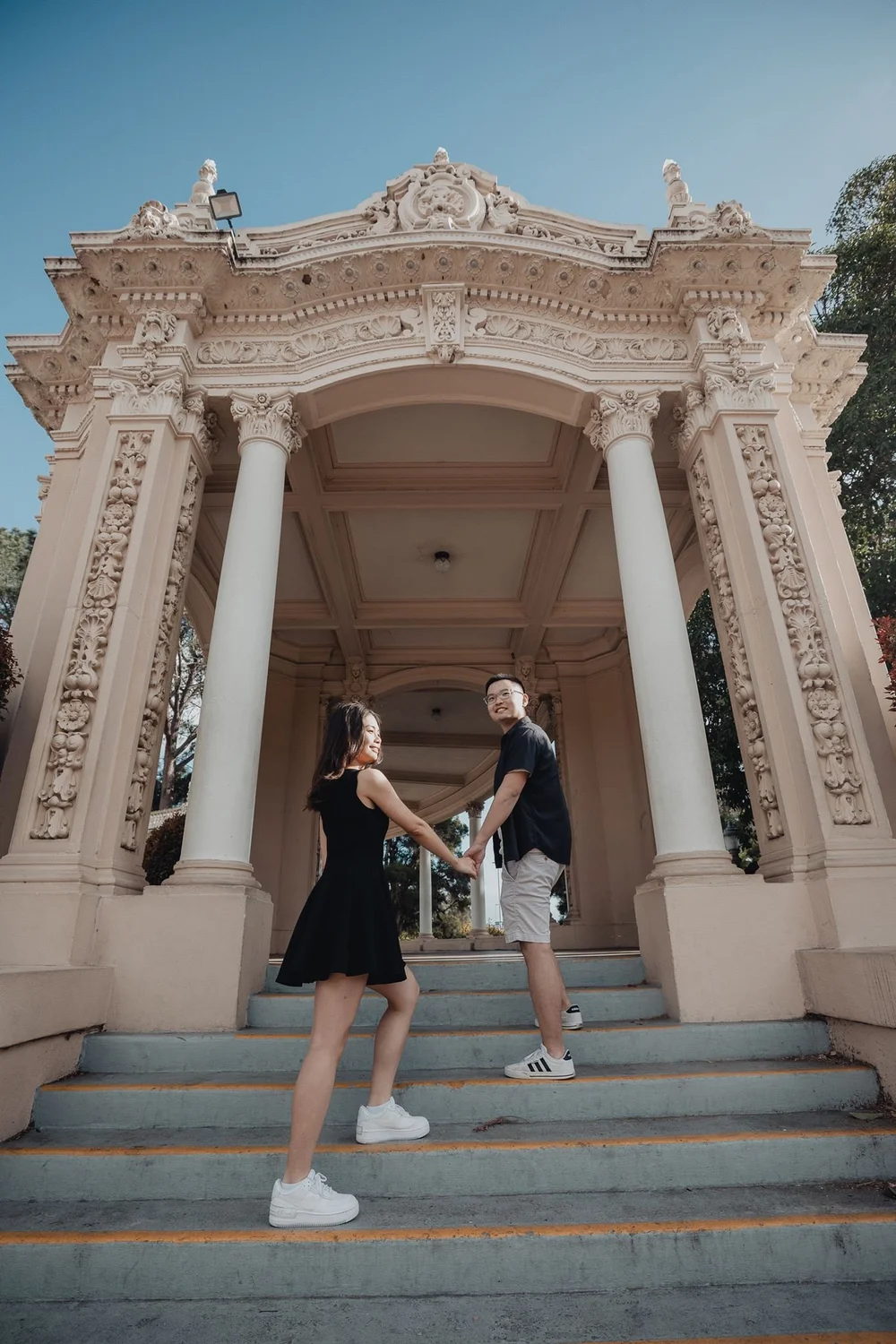Couple portrait beneath a Spanish Colonial colonnade at The Prado in Balboa Park