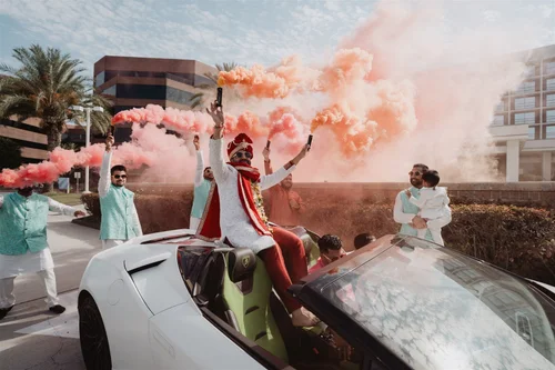 Baraat procession moving through coloured smoke