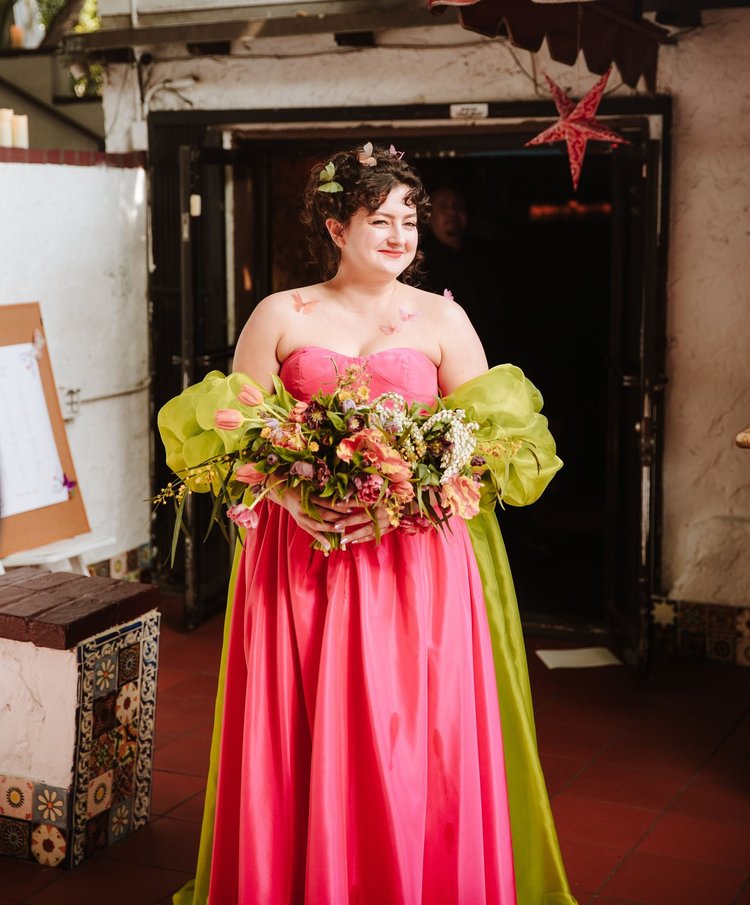 Bride in a hot pink ball gown with chartreuse green chiffon draped at the shoulders