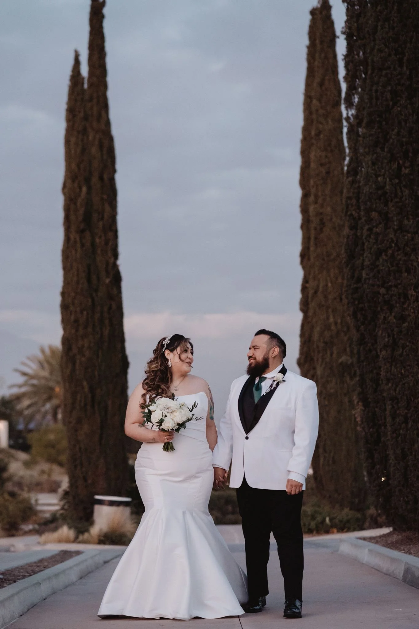 Couple between tall Italian cypress trees at dusk at Vellano Estate