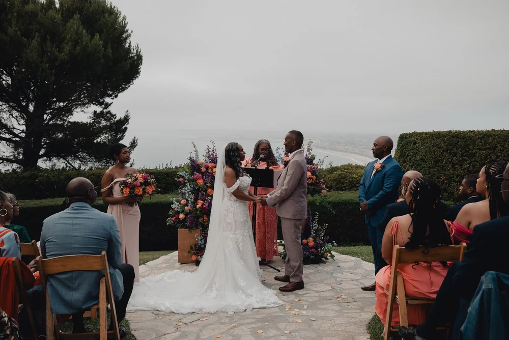 Garden ceremony at La Venta Inn with the Palos Verdes coastline behind the couple