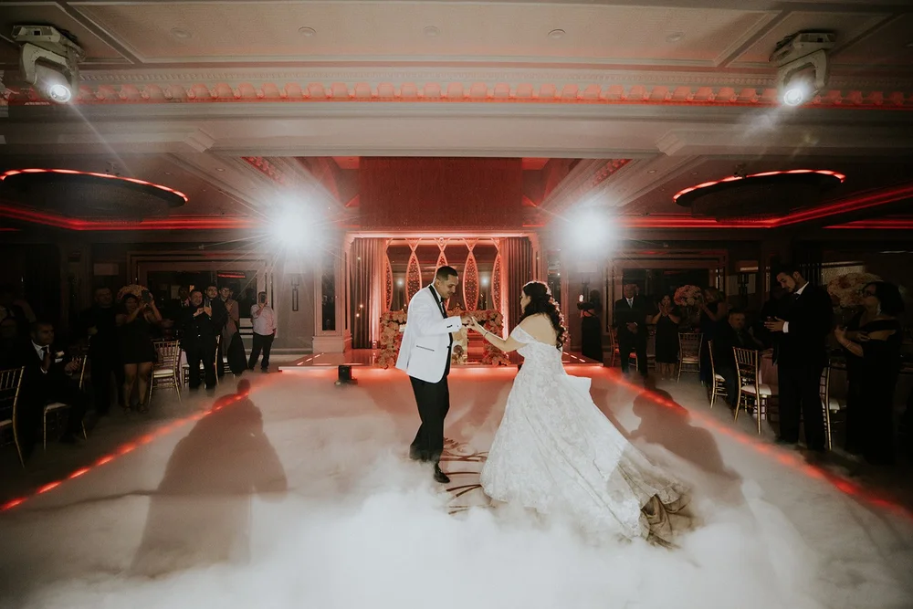 Couple dancing on fog under red uplighting at NOOR