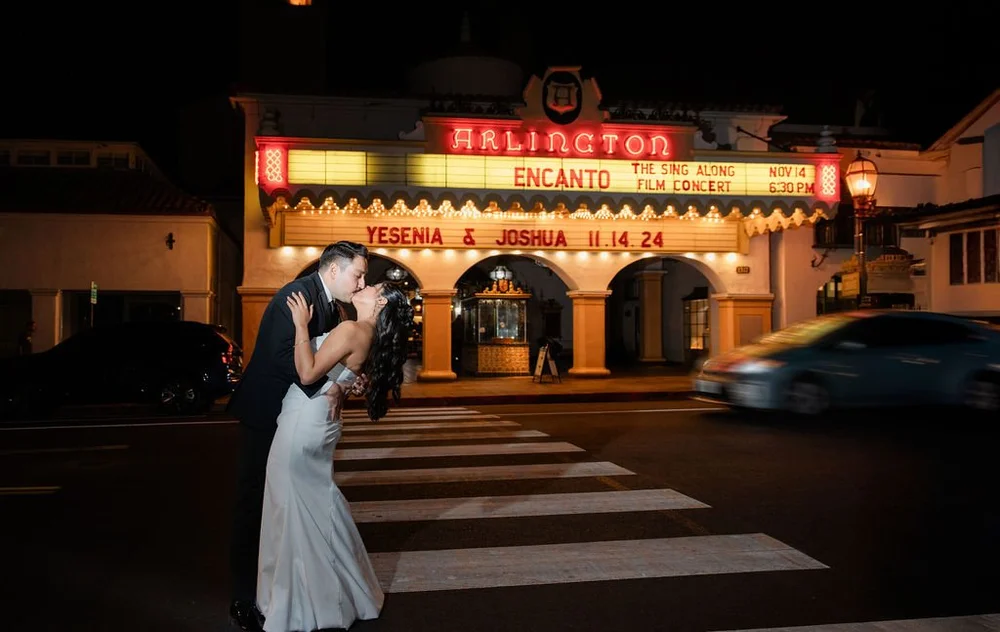 Couple kissing beneath the Arlington Theatre marquee at night
