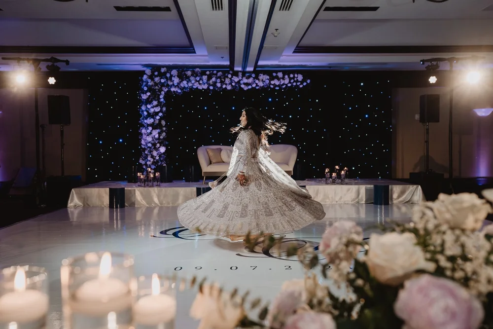Bride twirling on the dance floor beneath a starlit floral backdrop at NOOR in Pasadena