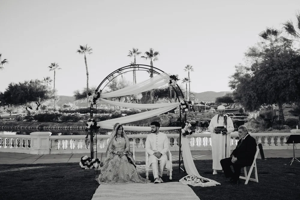 Black and white nikah beneath a floral arch on a lakeside terrace in Las Vegas