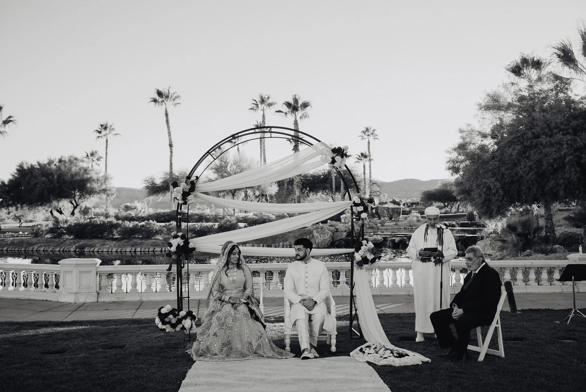Nikah ceremony under a round floral arch on the lawn by the balustrade at Siena Golf Club, black and white