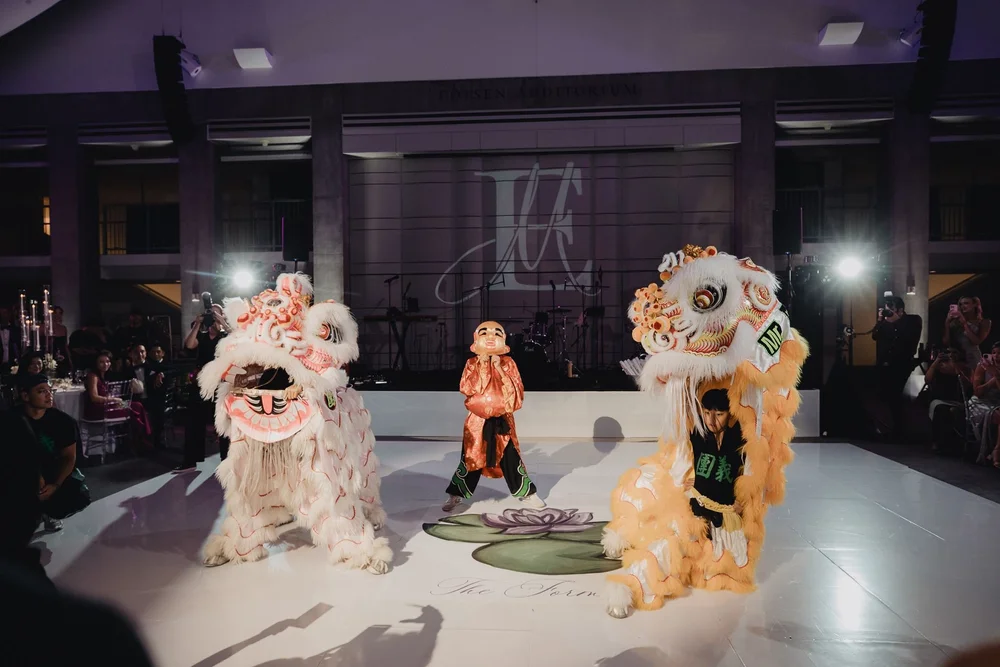 Lion crouching over the lettuce and red envelope placed on the dance floor during the choi cheng